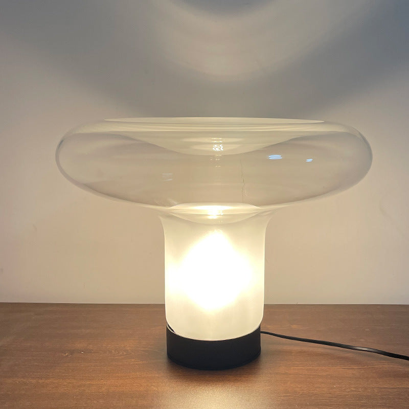 Modern table lamp with a glass shade on a wooden surface