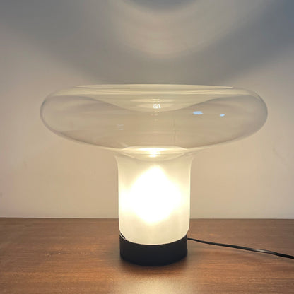 Modern table lamp with a glass shade on a wooden surface