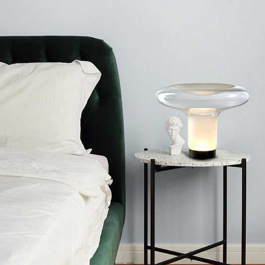 Modern nightstand with a lamp next to a bed in a bedroom setting